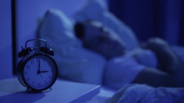 Reloj y hombre dormido en el fondo — Vídeos de Stock