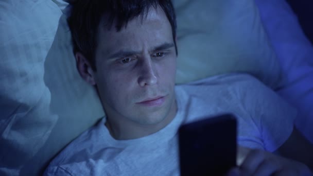 Uomo con smarthone in un letto di notte — Video Stock