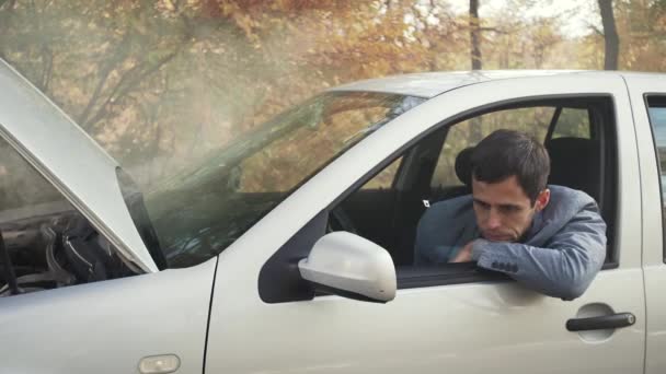 Hombre trastornado en un coche roto — Vídeos de Stock