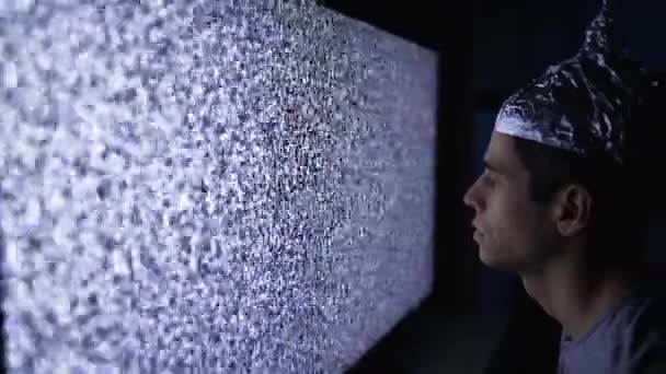 Homem em folha de lata chapéu parece quebrado aparelho de TV — Vídeo de Stock