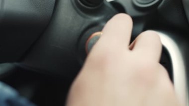 Adam arabayı anahtarla çalıştırıyor.