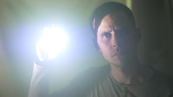 El hombre ilumina la cámara con una linterna — Vídeo de stock