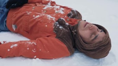 Donmuş adam karda yatıyor.