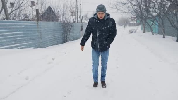 Mann läuft durch verschneites Wetter und rutscht — Stockvideo