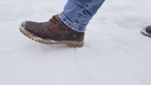 Pieds masculins marchant sur la neige — Video