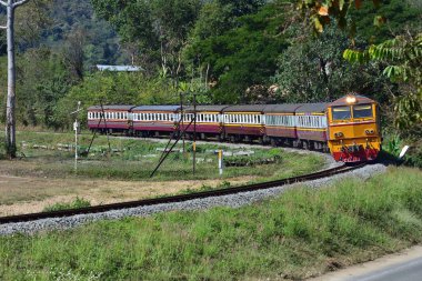 Tayland 'da dizel lokomotifle yolcu treni virajdan geçiyor.