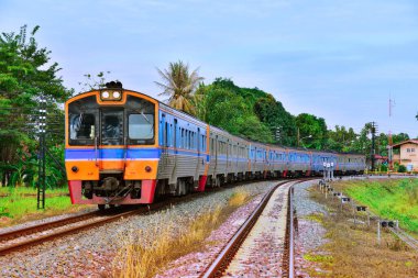 Diesel railcar passes the curve on railway in Thailand