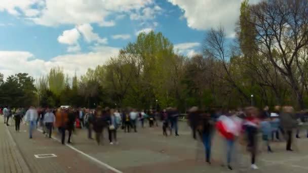 Лапс часу ходячі люди на фоновому синьому небі, хмарах і деревах — стокове відео
