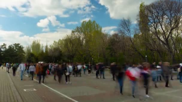 Time Lapse walking people on background blue sky, clouds and trees