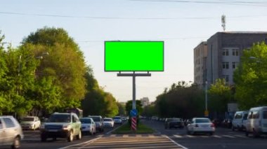 İçinde arabalar, yürüyen insanlar, ağaçlar, mavi gökyüzü ve binalar olan yeşil ekranlı bir reklam panosu. Ermenistan 'da, Erivan şehrinde.