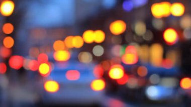Akşamları renkli Bokeh 'lerin trafik ışıkları ve hareket arabalarının olduğu hızlandırılmış video. Şehir akşam trafiği Bokeh.