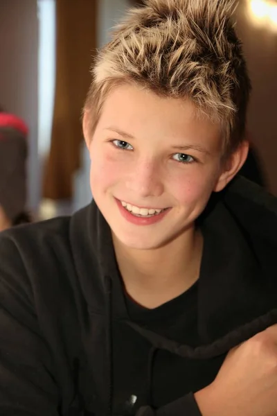 Uśmiechnięty chłopiec z pięknymi niebieskimi oczami patrzy przed siebie — Zdjęcie stockowe
