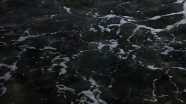 Gün ışığında deniz kıyısı köpüğü dalgası.
