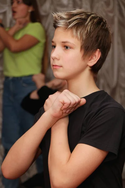 A teenager in an acting class expresses the emotion of rejection by crossing his arms over his chest. — Stock Photo, Image