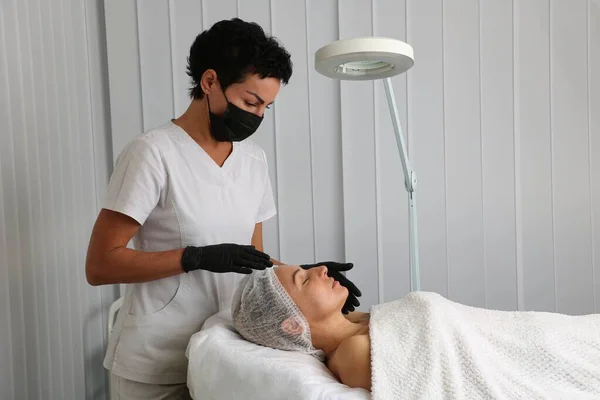 Le patient s'allonge sur le canapé avant l'intervention chez l'esthéticienne — Photo