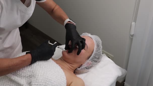 Lower lip augmentation and volume with fillers in a beauty salon — Stockvideo