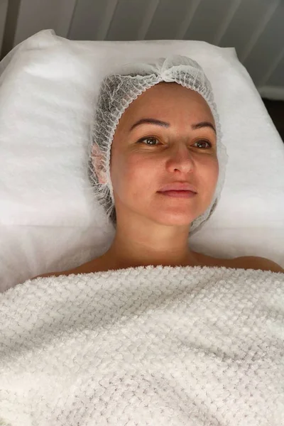 Adult woman in a beauty salon on a facial rejuvenation procedure — Foto de Stock