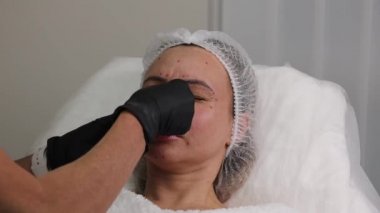 Beautician makes wrinkle injections according to marks