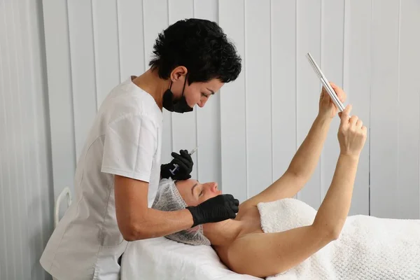 Esthéticien Examine Visage Patient Regardant Dans Miroir Après Une Procédure — Photo