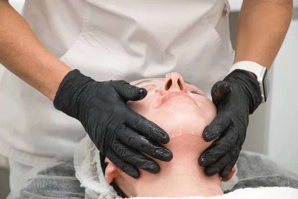 Крупный план пациентки в увлажняющей маске после процедуры омоложения электрической волны — стоковое фото