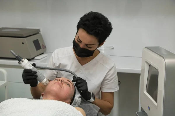 Resserrement de la peau du visage à l'aide d'ondes radio électriques pour une femme de plus de quarante ans — Photo