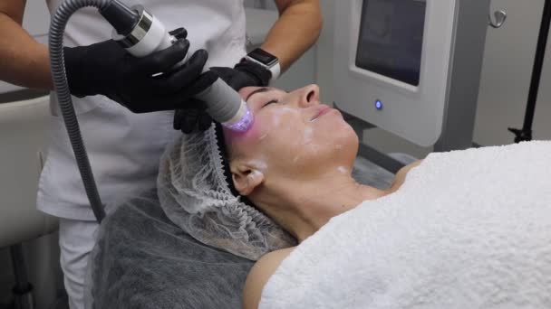 Skin rejuvenation by electric radio waves, in the area of the temples of an adult woman, in a cosmetology beauty salon — Stock Video