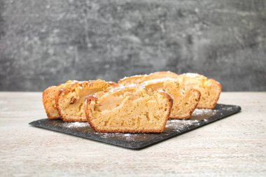 Elmalı turta, eşit parçalara bölünmüş, üzerine pudra şekeri serpilmiş.