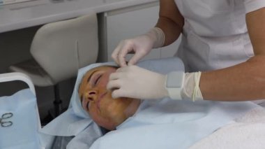 Kanepede uzanan yetişkin bir kadın için yüz gerdirme, yakın plan..