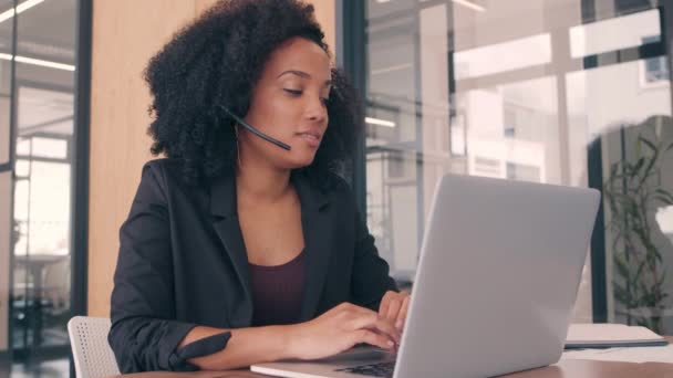 Una mujer que usa auriculares de centro de llamadas en una oficina moderna — Vídeo de stock