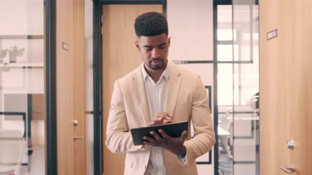 Businessman walking while using a digital tablet — Stock video