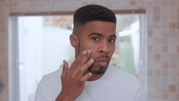 Felvétel egy férfiról, aki kozmetikai terméket visz az arcára — Stock videók