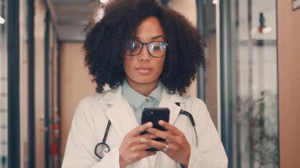 Záběry ženského lékaře stojící u jejího telefonu — Stock video