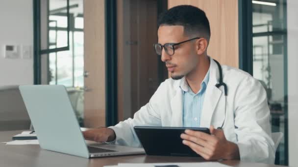 Medico di sesso maschile utilizzando un tablet e un computer portatile — Video Stock