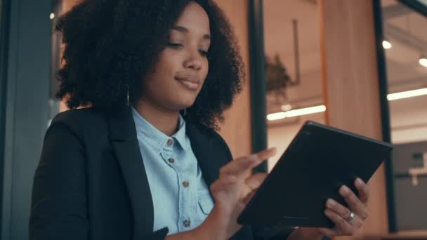 Una mujer de negocios sola en su oficina y usando una tableta — Vídeos de Stock
