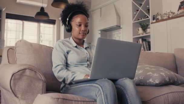 Una mujer atractiva usando un ordenador portátil en casa — Vídeos de Stock