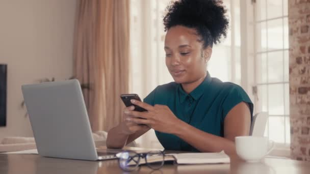 Mujer de negocios sentada en su oficina usando un teléfono celular — Vídeos de Stock