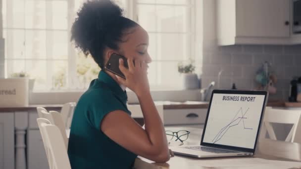 Mujer de negocios sentada sola en su oficina en casa hablando por su teléfono celular — Vídeos de Stock