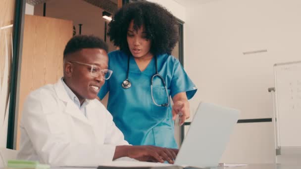 A doctor and a nurse working together in their office — Stockvideo