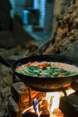 Ateşte yemek pişirmek.