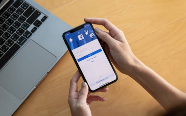 CHIANG MAI, THAILAND - OCT 03, 2018: Facebook sosyal medya uygulaması logosu giriş, mobil uygulama kayıt sayfası iPhone X üzerinde e-ticaret alışveriş işi yapan kişilerin elinde çalışan kişiler.