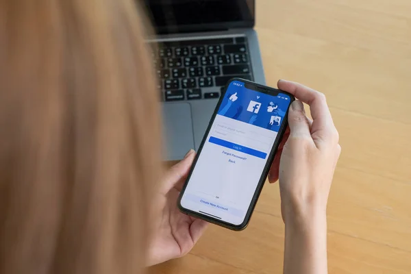 CHIANG MAI, TAILANDIA - 03 OCT 2018: Facebook social media app logo on log-in, sign-up registration page on mobile app screen on iPhone X in persons hand working on e-commerce shopping business — Foto de Stock