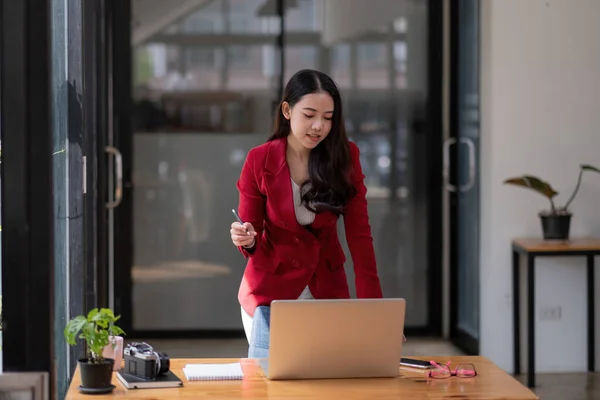 Charmante asiatische Geschäftsfrau steht auf Laptop im Büro — Stockfoto