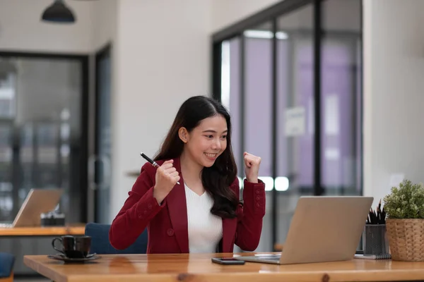 Portrait of success business asian woman enjoy success with laptop on work desk. Authentische Schuss freudige Frau bekam Jackpot, überrascht und feiert ihren Sieg. — Stockfoto
