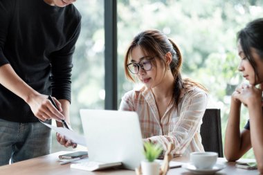 İş dünyasından Asyalı insanlar finansal veriler ve pazarlama büyüme raporlarıyla analiz etmeyi takım halinde, şirket karlı strateji planlama için sunum ve beyin fırtınası grafiği üzerinde tartışırlar.