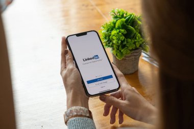 CHIANG MAI, THAILAND, OCT 17, 2021: Bir kadın Apple iPhone 'u ekranda LinkedIn uygulaması ile maksimum düzeyde tutuyor. LinkedIn akıllı telefonlar için fotoğraf paylaşım uygulaması