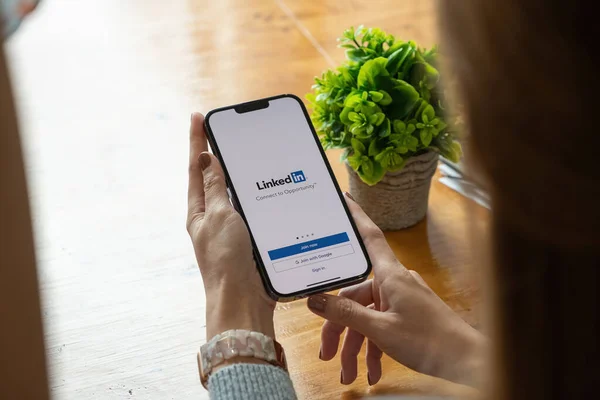 CHIANG MAI, TAILANDIA, 17 OCT 2021: Una mujer sostiene Apple iPhone pro max con la aplicación LinkedIn en la pantalla.LinkedIn es una aplicación para compartir fotos para teléfonos inteligentes — Foto de Stock