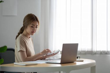 Bilgisayarlı hesap makinesi kullanan iş kadını, muhasebe, bütçe ve kredi kağıtları