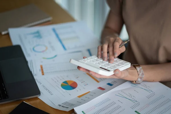 Close up Mulher de negócios usando calculadora e laptop para fazer finanças matemáticas em mesa de madeira no escritório e negócios trabalhando fundo, imposto, contabilidade, estatísticas e conceito de pesquisa analítica. — Fotografia de Stock