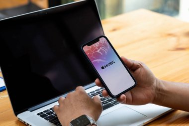 CHIANG MAI, THAILAND - 22,2021: iPhone 12 'de Apple müzik uygulamasının el ele görüntüsünü gösteren bir adam. Apple Music, iPhone 'a gelen iTunes tabanlı yeni müzik akış servisidir.