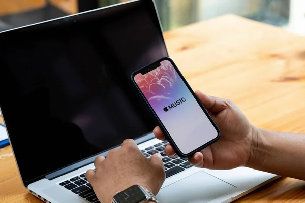 CHIANG MAI, THAILAND - AUG 22,2021: En man hand hålla skärmdump av Apple musik app som visas på iPhone 12. Apple Music är den nya iTunes-baserade musik streaming-tjänst som kom på iPhone — Stockfoto